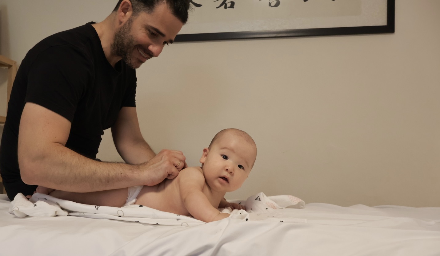 אודי קרסנר במהלך טיפול שונישין עדין לתינוק — מגע חם, רגוע ומלא ביטחון